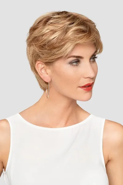 Vrouw met een kort, honingblond haarwerk met warme highlights, volume op de kruin en een zijwaarts geföhnde pony.